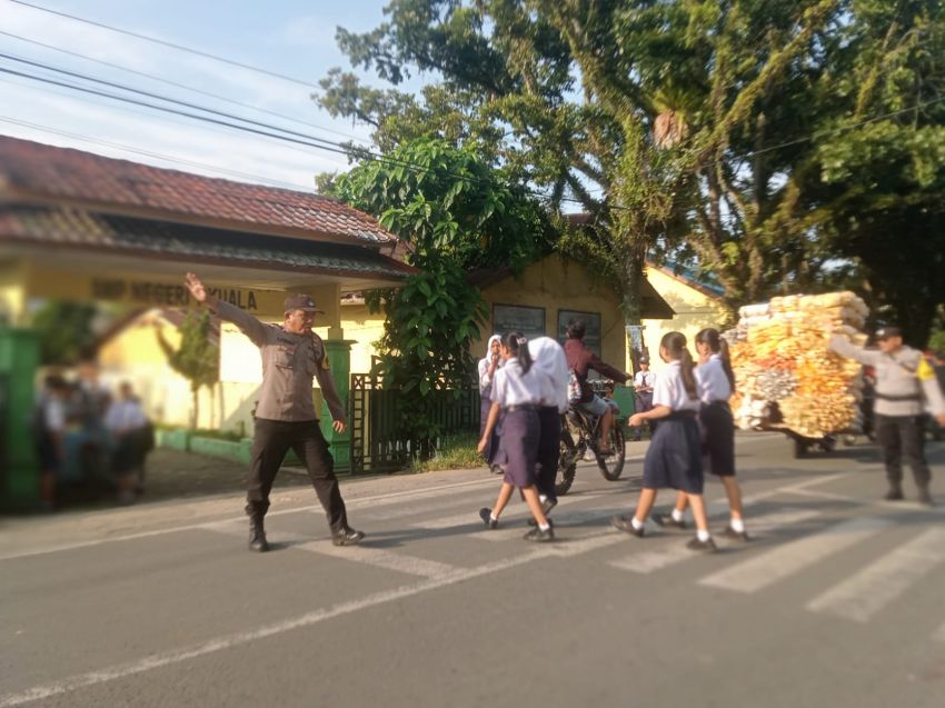 Bhabinkamtibmas Polsek Kuala Atur Lalu Lintas di Depan SMPN 1