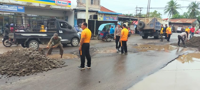 Bersama Warga, Personel Polsek Tanjung Pura Timbun Jalan